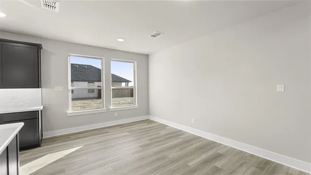 a view of kitchen with kitchen island microwave and wooden floor