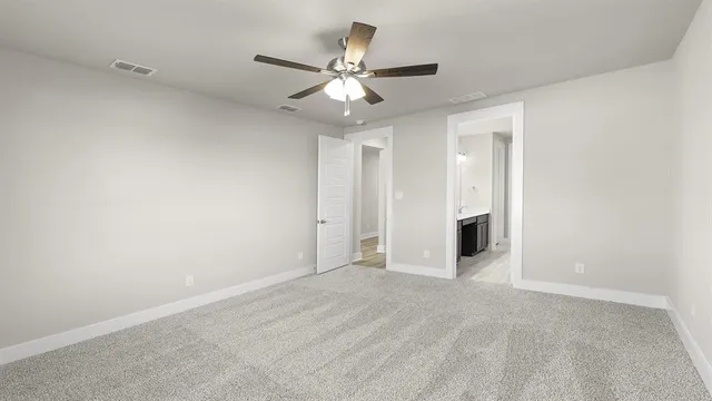 an empty room with a window and a ceiling fan