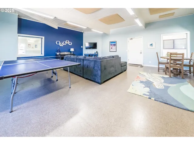 a living room with stainless steel appliances furniture and a flat screen tv