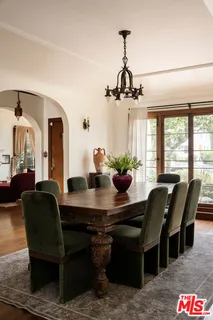 a kitchen with stainless steel appliances granite countertop a stove a sink dishwasher and white cabinets with wooden floor