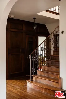 a room with painting on the wall and a potted plant