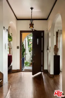 a view of a hallway with wooden floor and windows