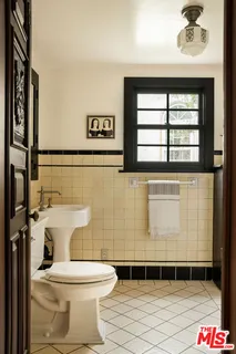 a bathroom with a sink a toilet and shower curtain