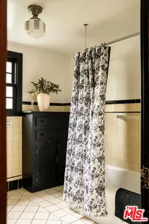 a bedroom with a bed and two large window