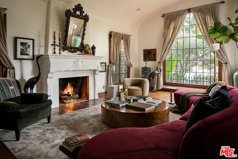 a living room with furniture fireplace and a large window
