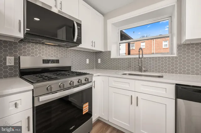 a kitchen with granite countertop cabinets stainless steel appliances and a sink