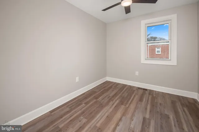 a view of an empty room with a fan and a window