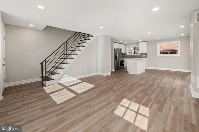 a view of entryway with kitchen and wooden floor