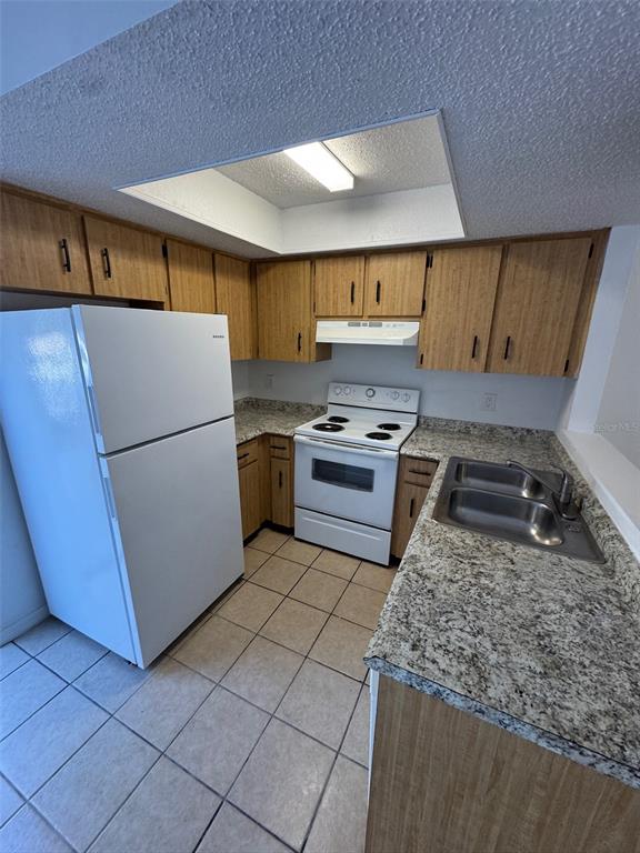 1735 Northeast 14th Street Ocala, FL 34470 - Photo 8 of 17 a kitchen with a refrigerator a stove top oven a sink and cabinets