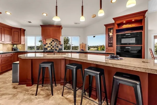 a large kitchen with kitchen island a large island in the center and stainless steel appliances