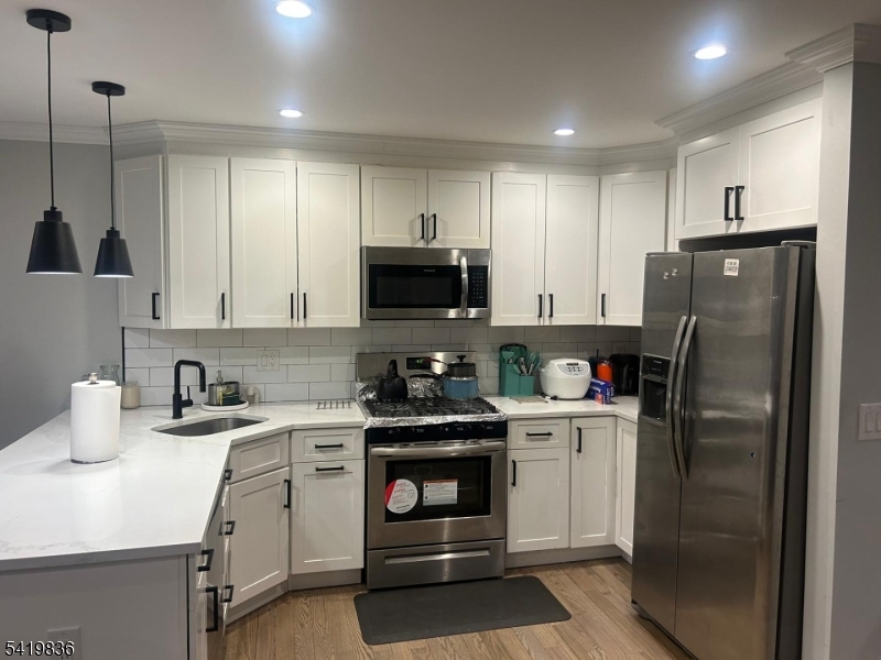 15-17 Rector Avenue Woodbridge, NJ 07095 - Photo 11 of 33 a kitchen with a sink a refrigerator and cabinets