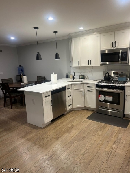 15-17 Rector Avenue Woodbridge, NJ 07095 - Photo 7 of 33 a kitchen with stainless steel appliances granite countertop a stove top oven a sink dishwasher and white cabinets with wooden floor