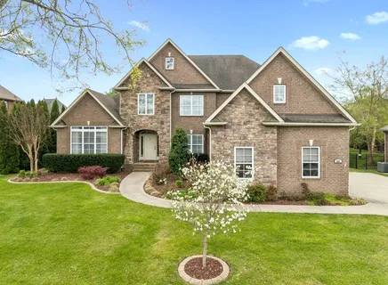 a front view of a house with yard and green space