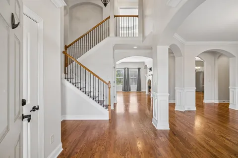 a view of staircase with wooden floor and a chandelier