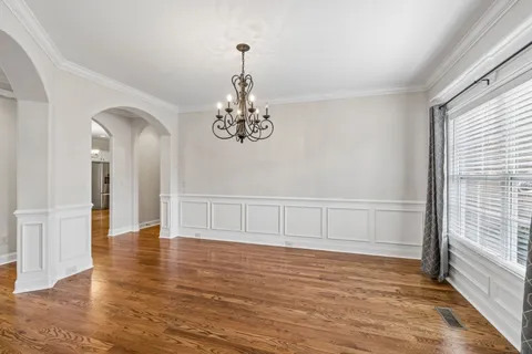 a view of a room with chandelier fan and wooden floor