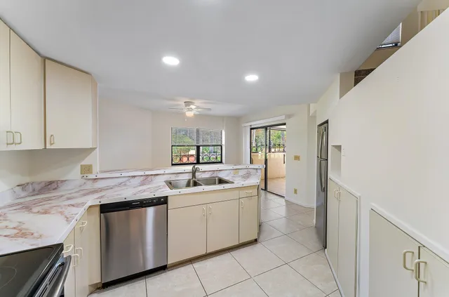 a kitchen with stainless steel appliances granite countertop a refrigerator and a stove top oven