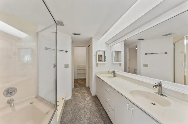 a spacious bathroom with a bathtub shower sink vanity and a mirror