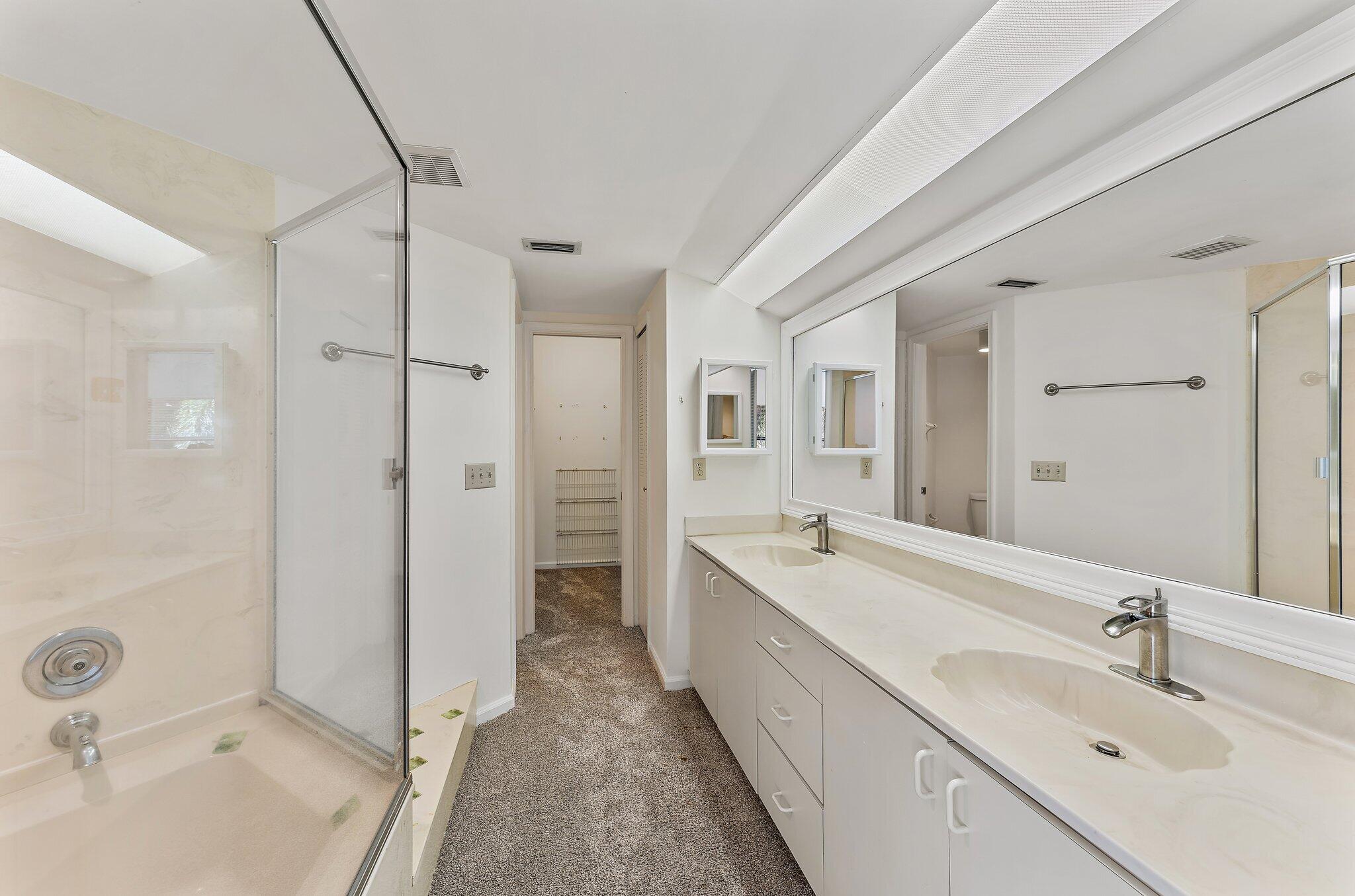 3 Uno Lago Drive, Unit 3 Juno Beach, FL 33408 - Photo 24 of 31 a bathroom with a double vanity sink mirror double and shower