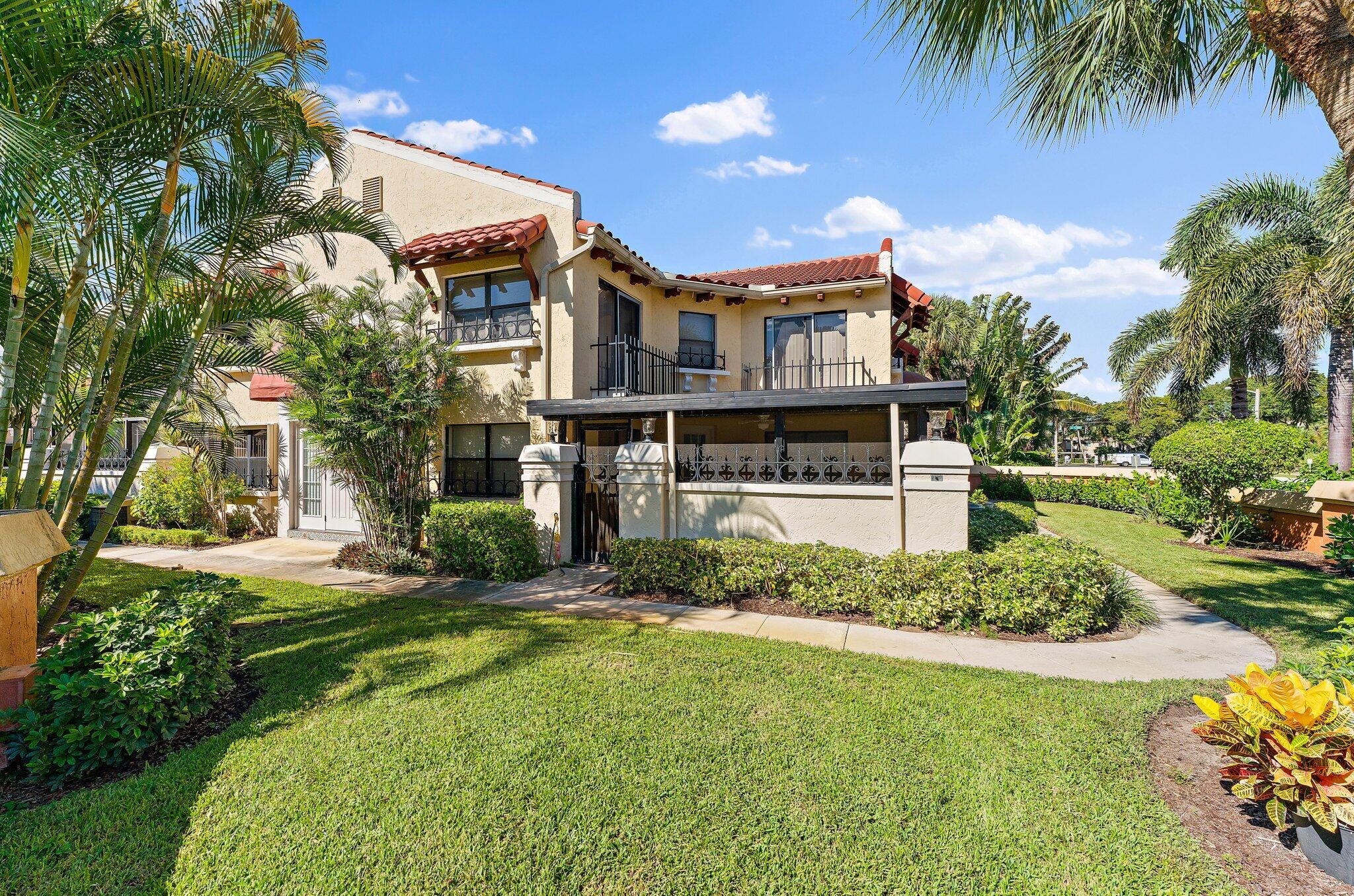 3 Uno Lago Drive, Unit 3 Juno Beach, FL 33408 - Photo 3 of 31 a front view of a house with a yard
