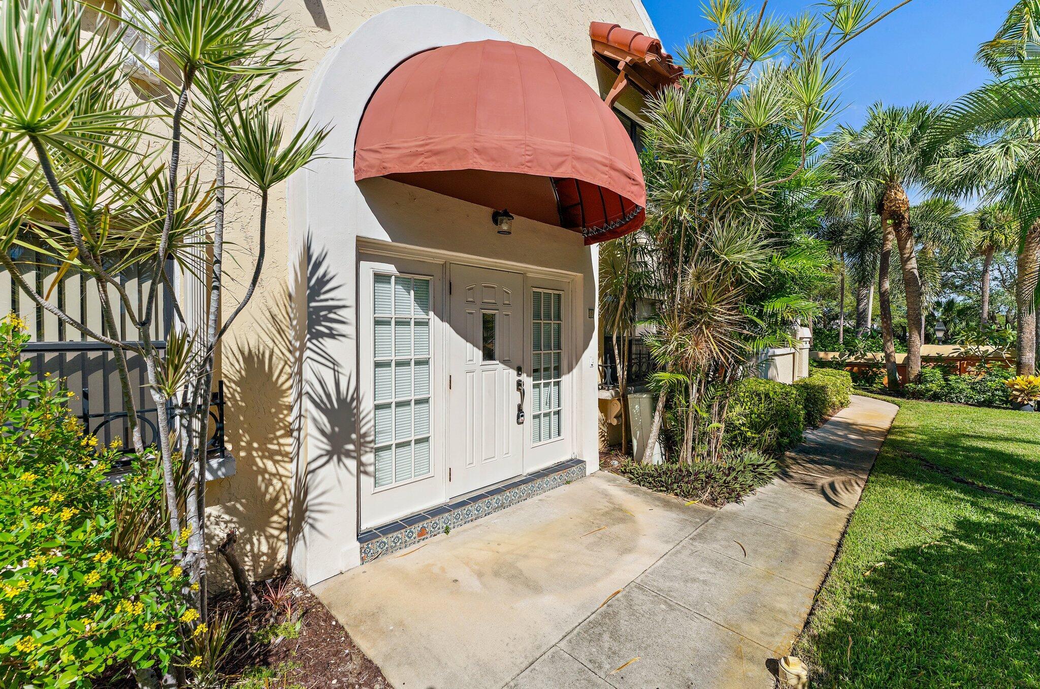 3 Uno Lago Drive, Unit 3 Juno Beach, FL 33408 - Photo 4 of 31 a front view of a house with a yard