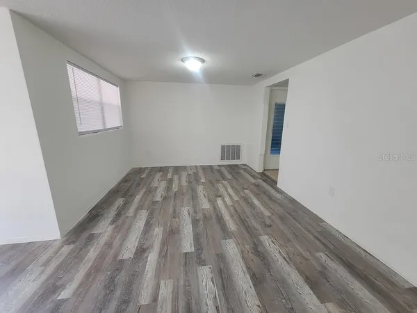 a view of empty room with wooden floor