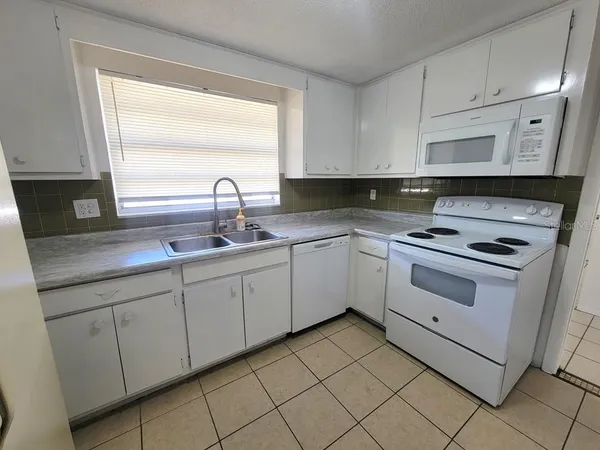 a kitchen with cabinets appliances and a window