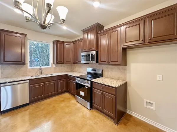 a kitchen with stainless steel appliances granite countertop a sink stove and cabinets