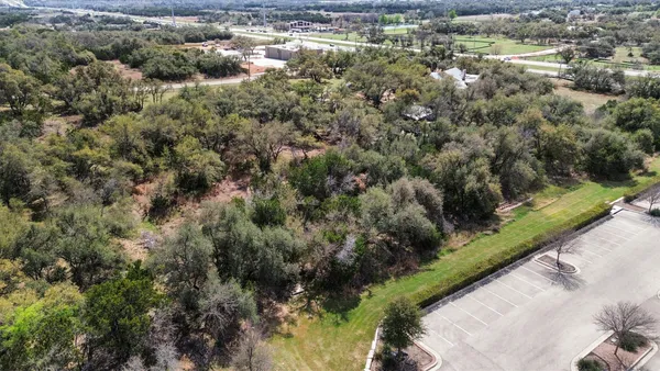 an aerial view of residential houses with outdoor space and trees