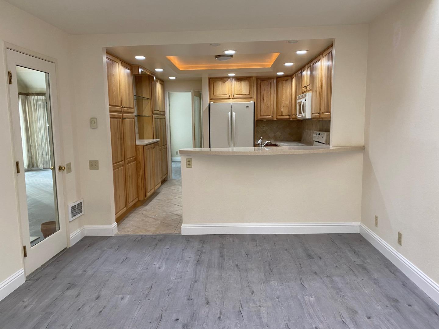 910 Wharfside Road San Mateo, CA 94404 - Photo 3 of 14 a view of a hallway with wooden floor and a kitchen