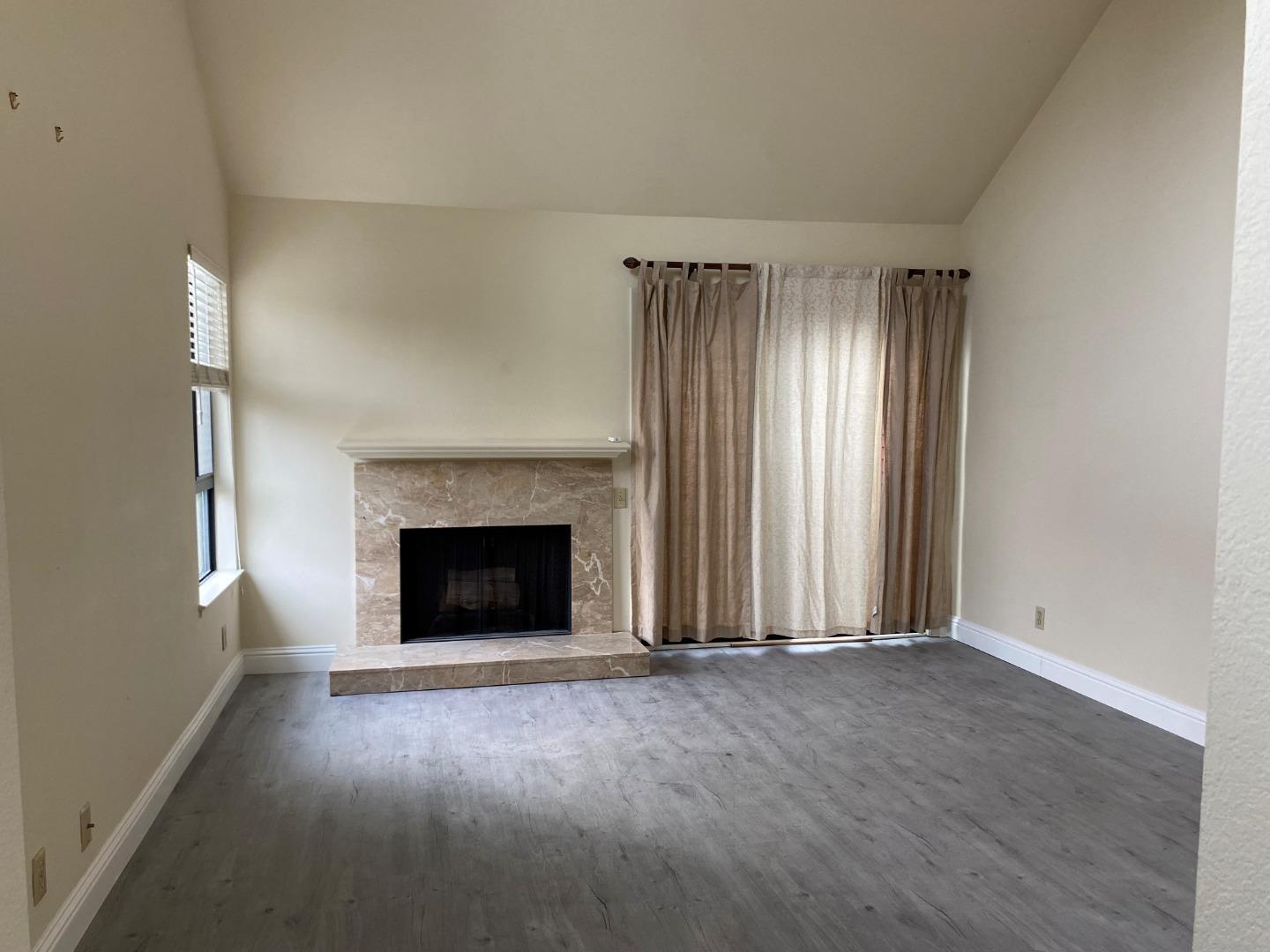 910 Wharfside Road San Mateo, CA 94404 - Photo 7 of 14 an empty room with windows and fireplace