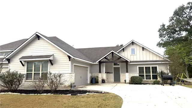 a front view of a house with a yard covered in snow