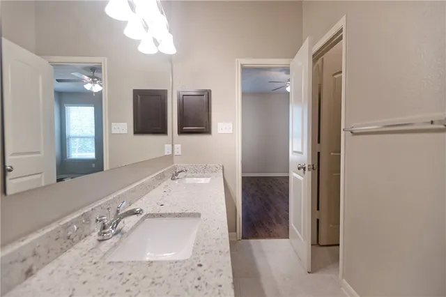 a bathroom with a granite countertop sink a mirror a shower and a bathtub
