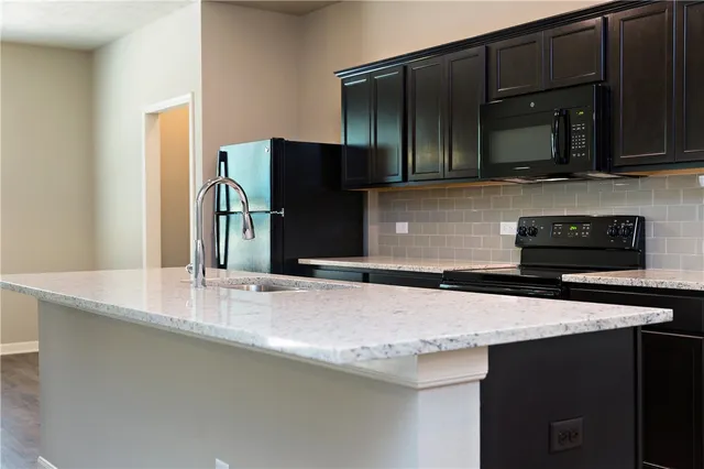 a kitchen with stainless steel appliances granite countertop a sink and a microwave