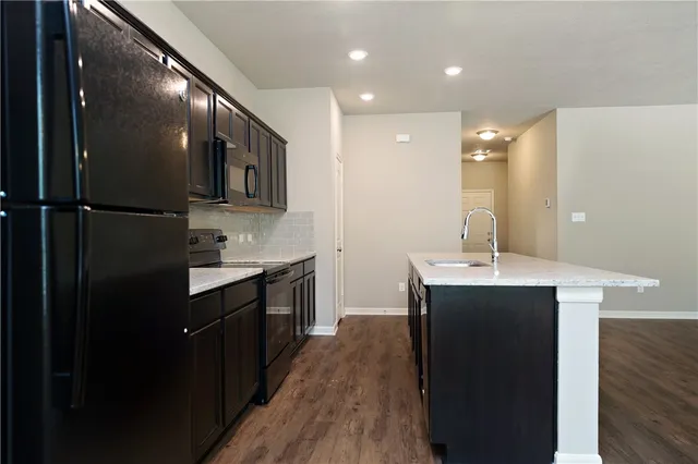 a kitchen with kitchen island sink stove and refrigerator