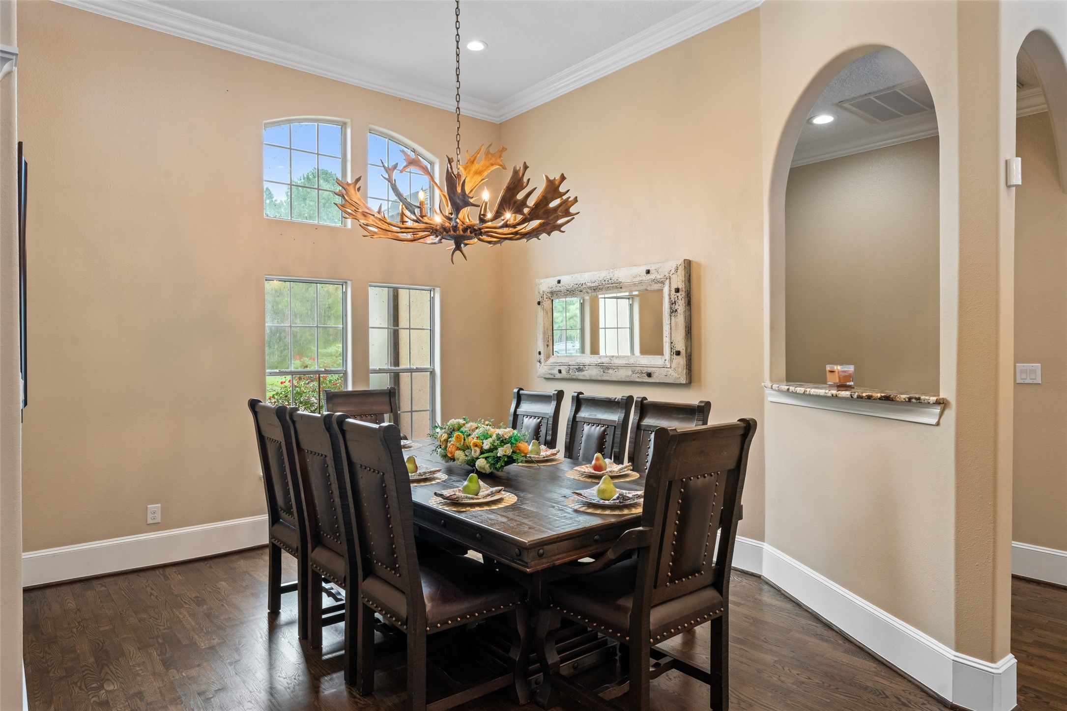 32660 Willow Bend Road Waller, TX 77484 - Photo 13 of 47 – Dedicated dining space accented by a statement chandelier, arched architectural details, wood flooring, and large windows overlooking the outdoors.