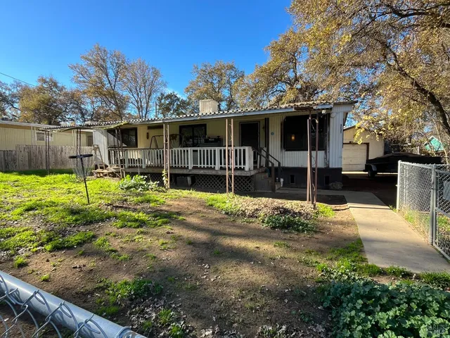 a backyard of a house with garden and barbeque oven