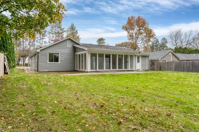 a front view of a house with a yard and trees