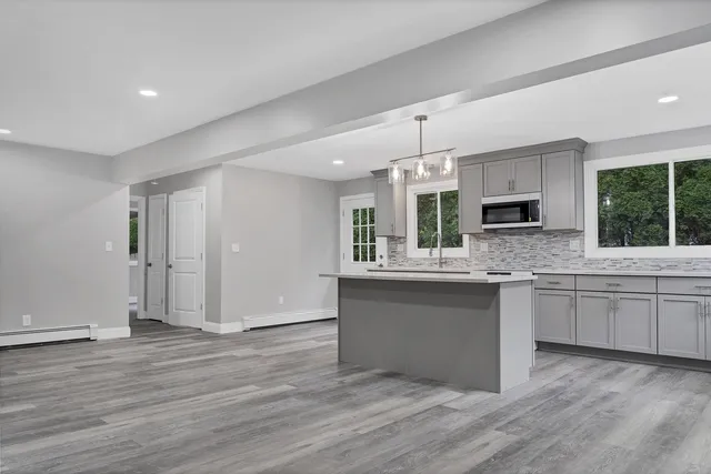a kitchen with granite countertop a oven and white cabinets