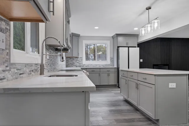 a kitchen with kitchen island a sink stainless steel appliances and cabinets