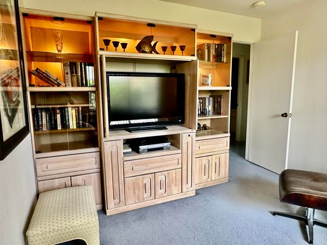 a kitchen with stainless steel appliances cabinets and a flat screen tv