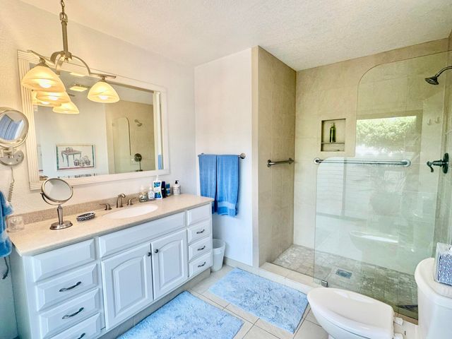 a spacious bathroom with a double vanity sink mirror double shower and a toilet