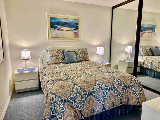 a bedroom with a bed a mirror and lamp