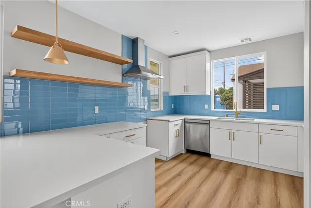a large kitchen with a sink dishwasher stove and white cabinets