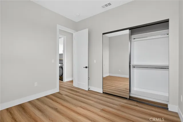 a view of room with wooden floor and closet