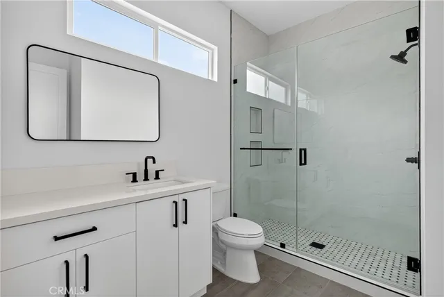a bathroom with a toilet sink vanity and mirror