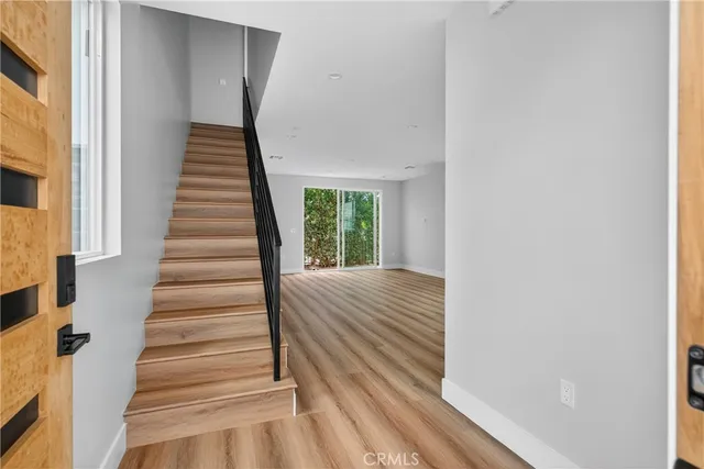 a view of a hallway with wooden floor and entryway