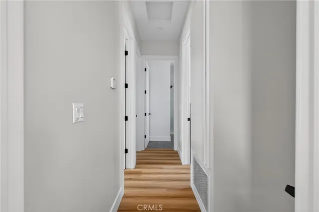 a view of a hallway with wooden floor and closet