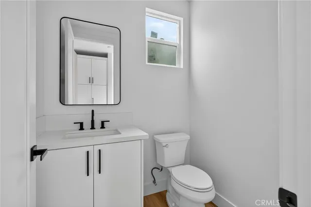 a bathroom with a toilet sink vanity and mirror