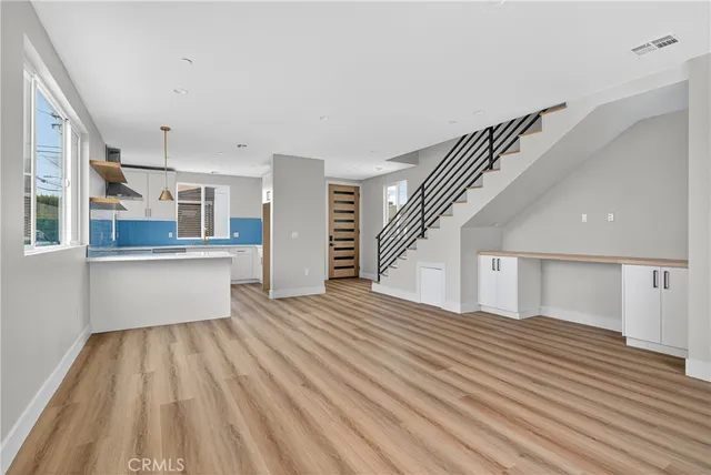 a view of a kitchen with wooden floor and electronic appliances