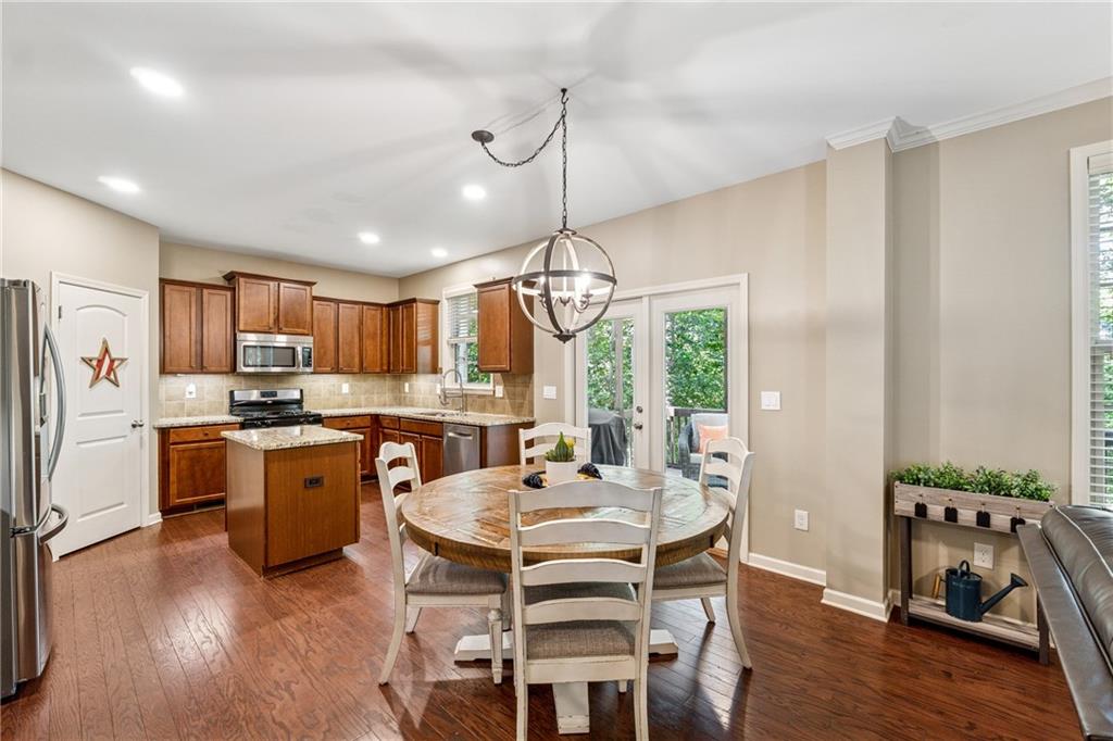 2770 Lansing Lane Cumming, GA 30041 - Photo 11 of 49 a kitchen with a refrigerator a stove a sink dishwasher with a dining table and chairs